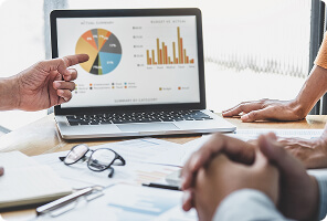 Team reviewing business analytics charts and graphs displayed on a laptop during a meeting